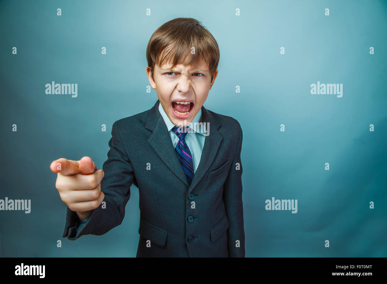 Teen boy screaming businessman points his finger at the head of Stock Photo