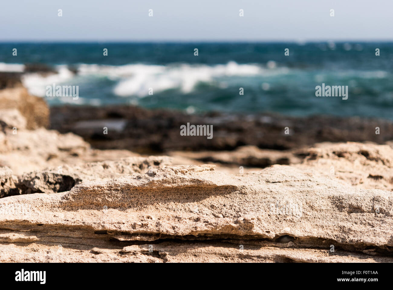 rocky shore with the sea waves and blue sky as a background Stock Photo ...