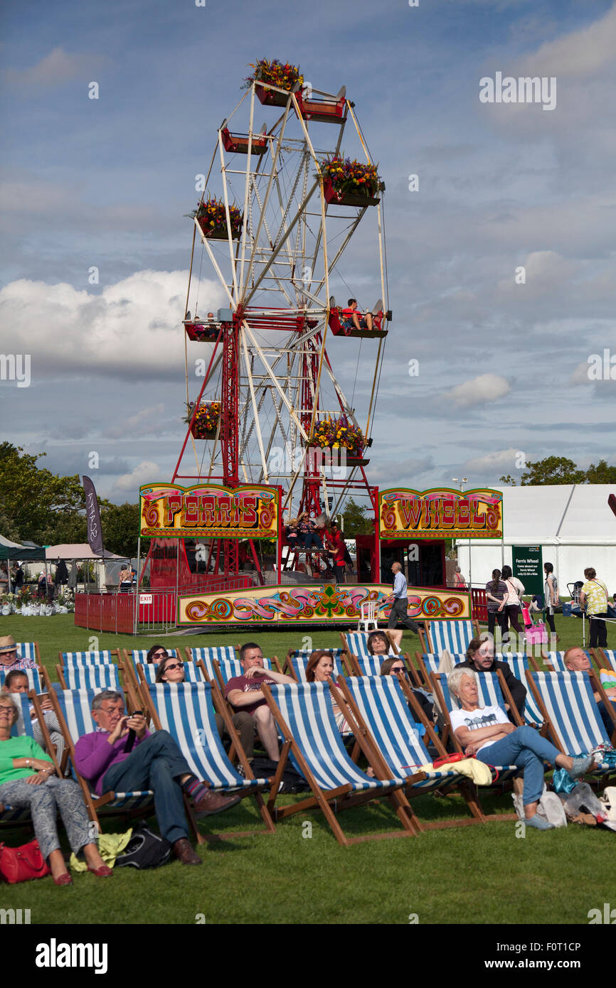 Big fairground ferris wheel, deck chairs and seating on a grand day out at Britain’s biggest independent flower show arena, celebrates with a carnival-like summer celebration in Southport, UK Stock Photo