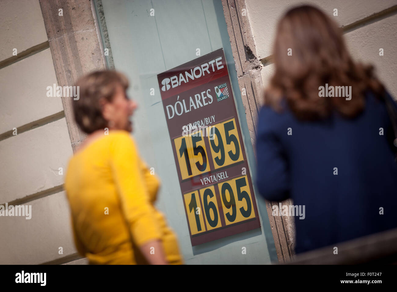 Mexico City, Mexico. 20th Aug, 2015. People pass by a board of a bank branch that shows the value of Mexican peso against US dollar in Mexico City, capital of Mexico, on Aug. 20, 2015. © Pedro Mera/Xinhua/Alamy Live News Stock Photo