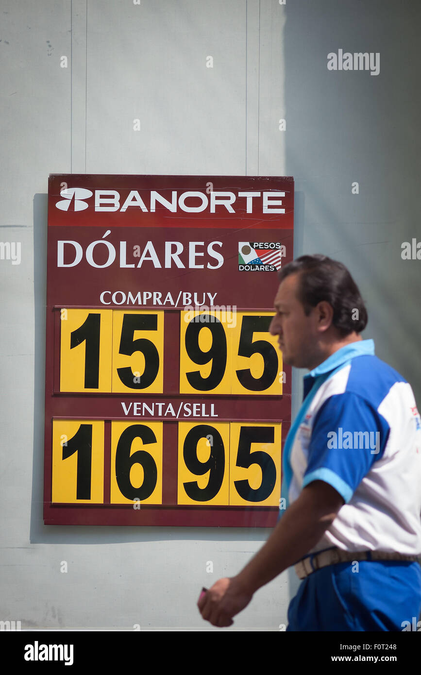 Mexico City, Mexico. 20th Aug, 2015. A man passes by a board of a bank branch that shows the value of Mexican peso against US dollar in Mexico City, capital of Mexico, on Aug. 20, 2015. © Pedro Mera/Xinhua/Alamy Live News Stock Photo