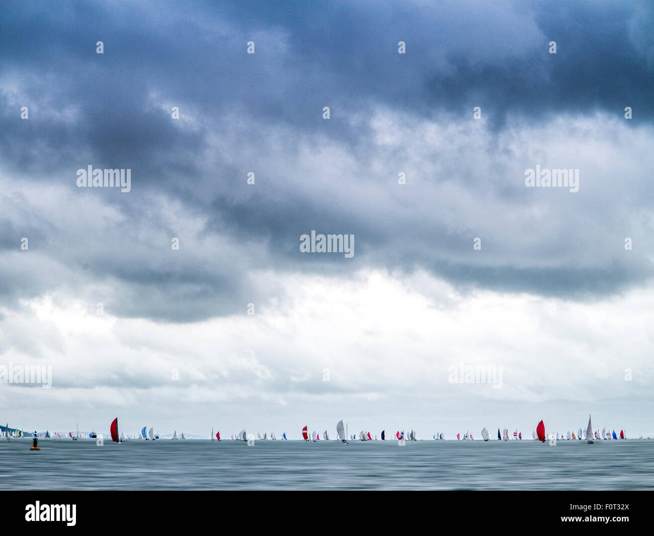Bright spinnakers under heavy skies at Cowes in 2015 Stock Photo