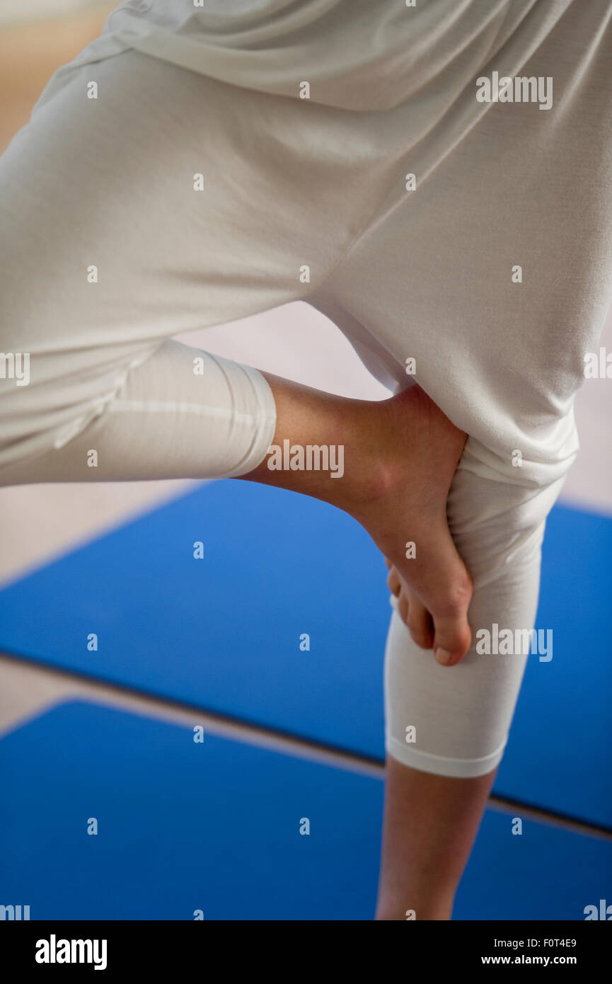 Young woman doing yoga, tree pose Stock Photo - Alamy