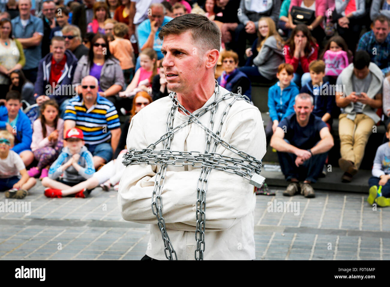 Street entertainer doing an act as an escapologist, The Mound, Edinburgh Fringe Festival, Scotland, UK Stock Photo