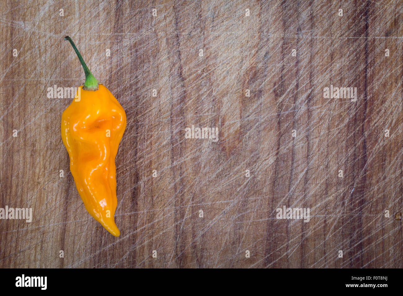 yellow fatalii chili pepper over wooden cutting board high angle view Stock Photo