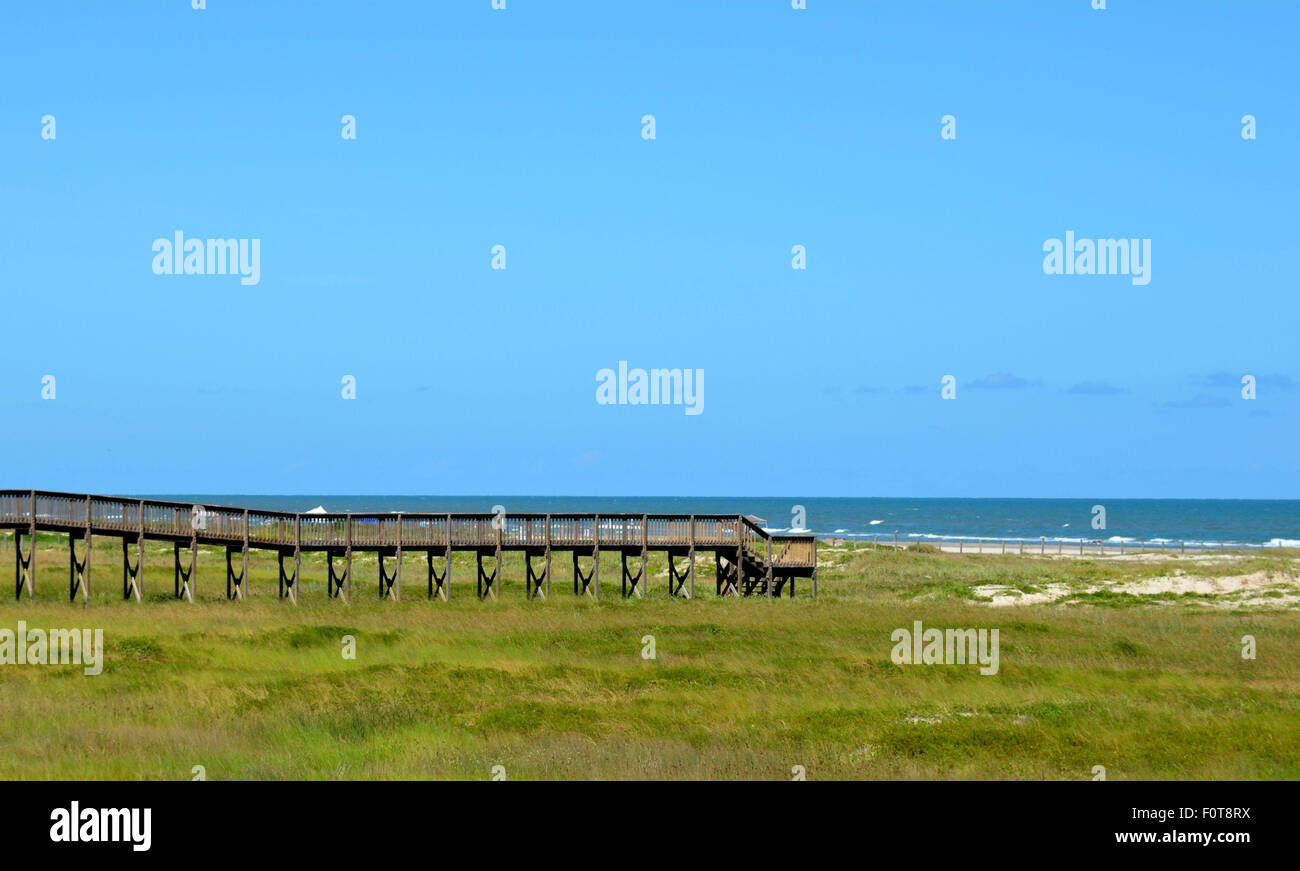 Beach bridge, extending over dunes of sand and grass.  Gulf of Mexico ocean beach front located at Galveston, Tx Stock Photo