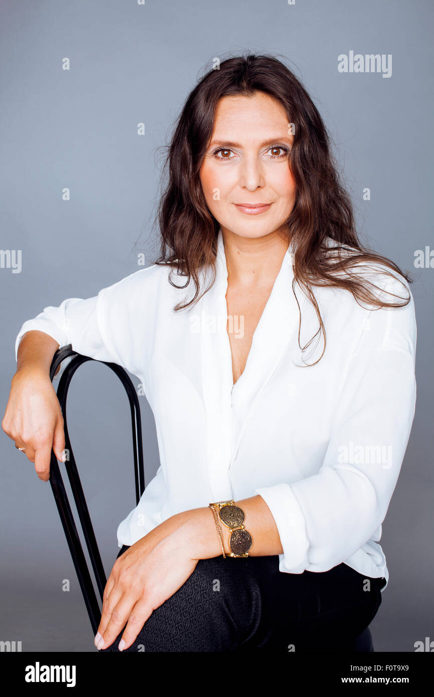 Mature woman sitting on chair hi-res stock photography and images - Alamy