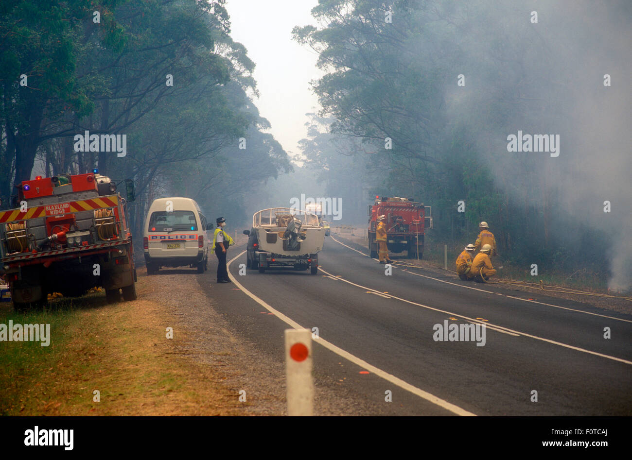 POLICE AND FIRE SERVICES STAND BY AS BUSH FIRES APPROACH A HIGHWAY, SYDNEY, NSW, AUSTRALIA Stock Photo