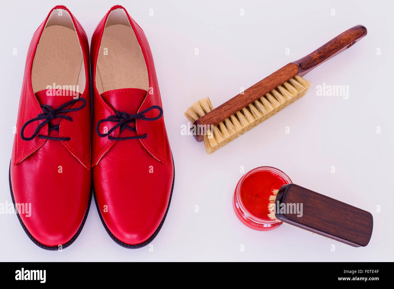 Isolated red shoes and means on care of footwear - shoe-polish and brush Stock Photo