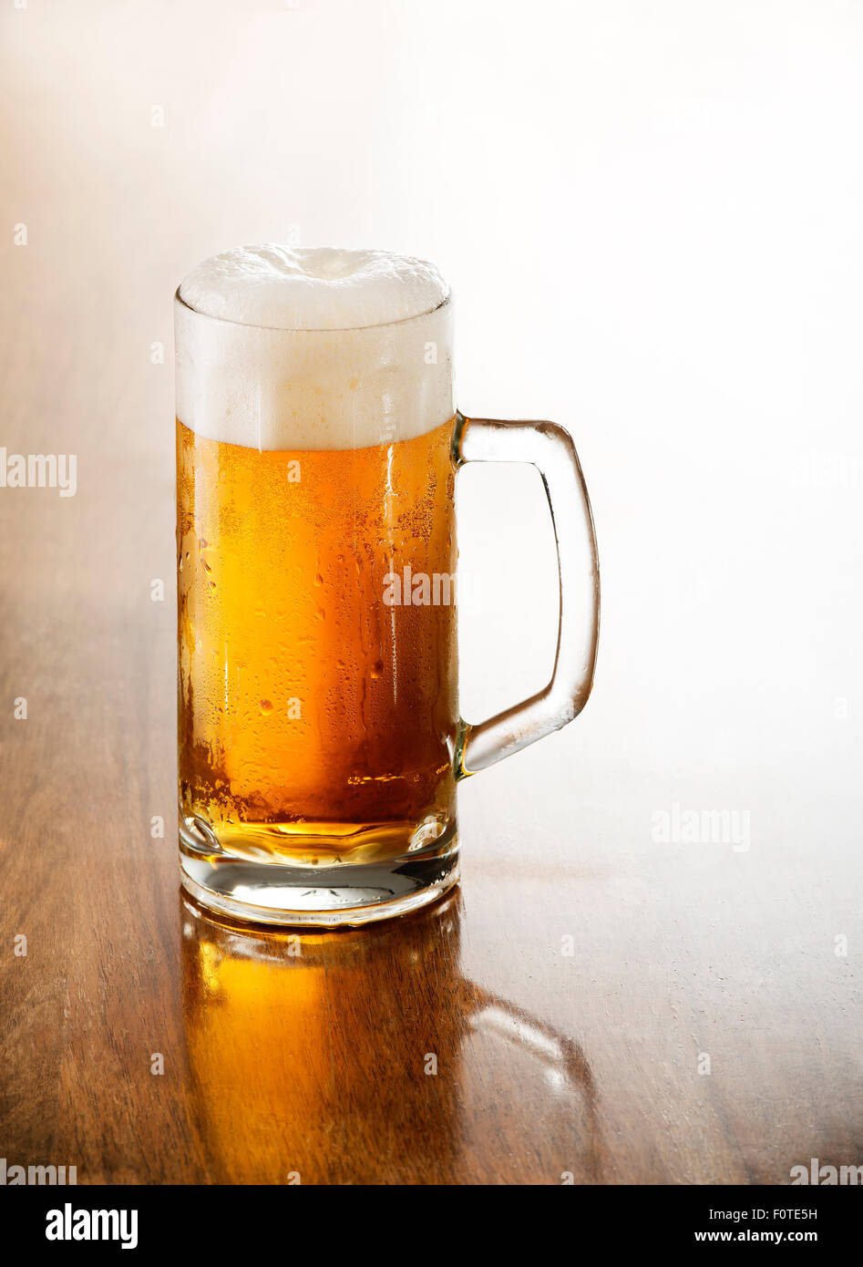 Glass of cold beer on a wooden table. Stock Photo