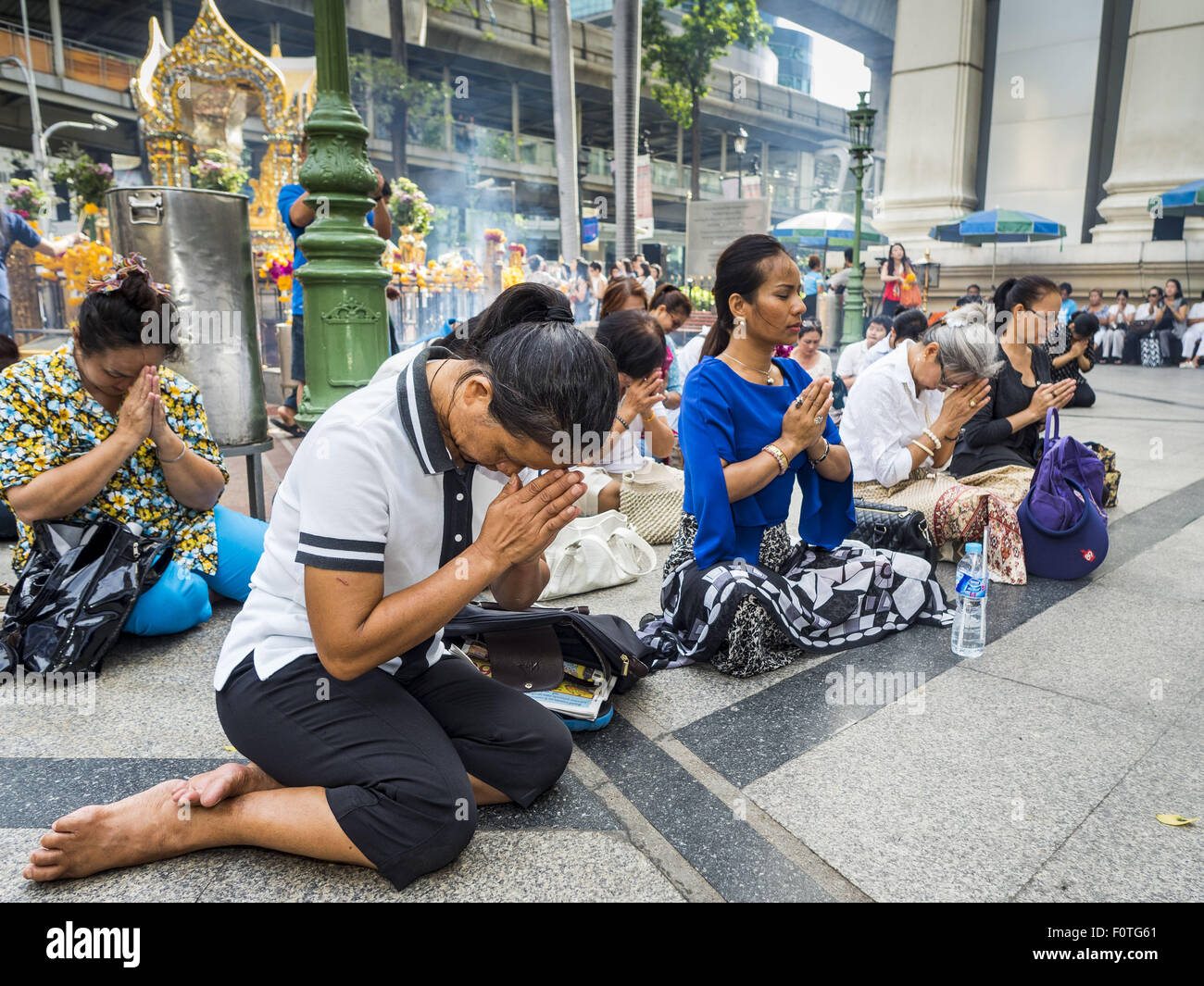 Bangkok, Thailand. 21st Aug, 2015. People gather on the plaza at Erawan Shrine for a Mahayana Buddhist ceremony to restore the shrine after the bombing. The Bangkok Metropolitan Administration (BMA) held a religious ceremony Friday for the Ratchaprasong bomb victims. The ceremony started with a Brahmin blessing at Erawan Shrine, which was the target of a bombing Monday night. After the blessing people went across the street to the plaza in front of Central World mall for an interfaith religious service. Credit:  ZUMA Press, Inc./Alamy Live News Stock Photo