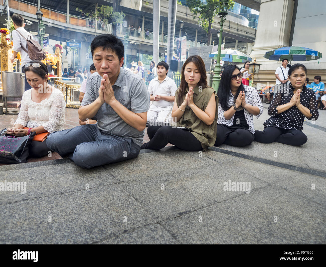 Bangkok, Thailand. 21st Aug, 2015. People gather on the plaza at Erawan Shrine for a Mahayana Buddhist ceremony to restore the shrine after the bombing. The Bangkok Metropolitan Administration (BMA) held a religious ceremony Friday for the Ratchaprasong bomb victims. The ceremony started with a Brahmin blessing at Erawan Shrine, which was the target of a bombing Monday night. After the blessing people went across the street to the plaza in front of Central World mall for an interfaith religious service. Credit:  ZUMA Press, Inc./Alamy Live News Stock Photo
