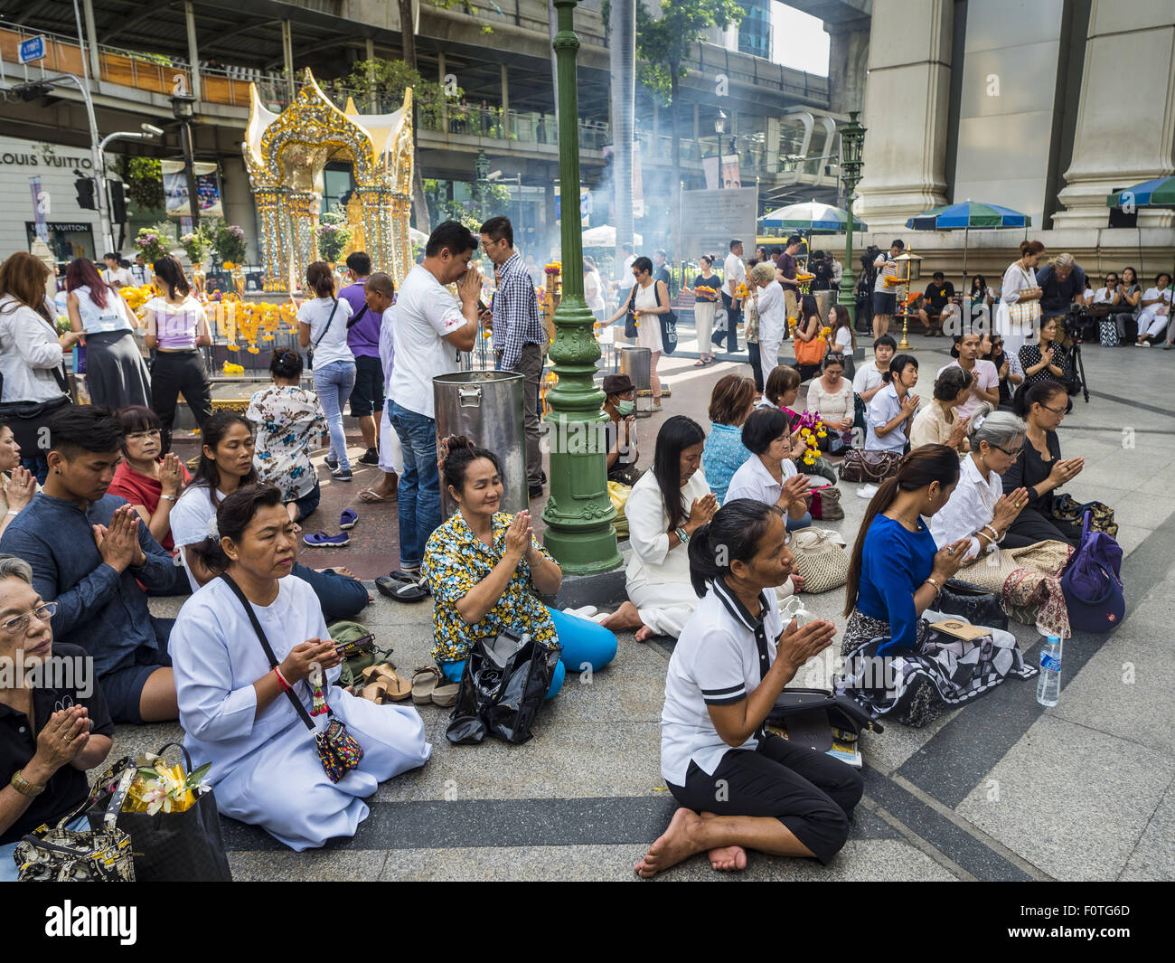 Bangkok, Thailand. 21st Aug, 2015. People gather on the plaza at Erawan Shrine for a Mahayana Buddhist ceremony to restore the shrine after the bombing. The Bangkok Metropolitan Administration (BMA) held a religious ceremony Friday for the Ratchaprasong bomb victims. The ceremony started with a Brahmin blessing at Erawan Shrine, which was the target of a bombing Monday night. After the blessing people went across the street to the plaza in front of Central World mall for an interfaith religious service. Credit:  ZUMA Press, Inc./Alamy Live News Stock Photo