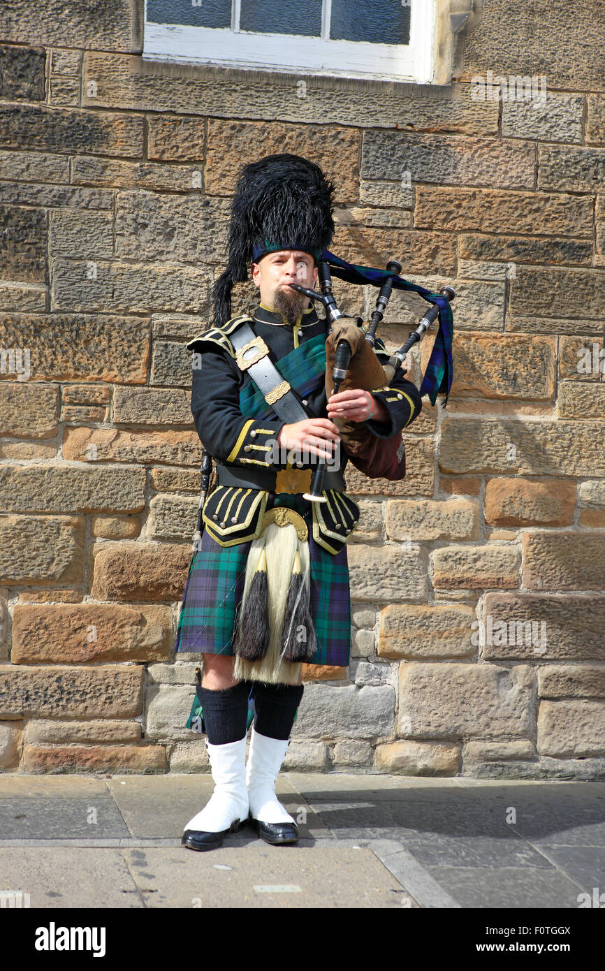 Scottish piper playing the bagpipes on the street in Edinburgh during