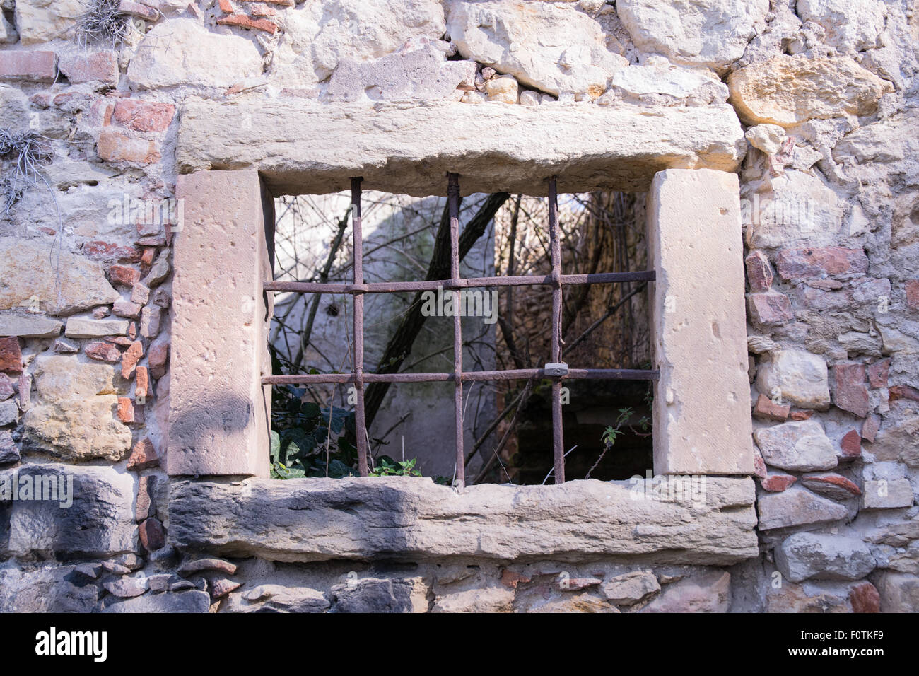 old window grille of a ruined castle in Italy Stock Photo