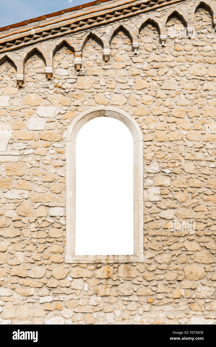 Arched window in the ancient medieval stone wall suitable as a frame or border. Stock Photo