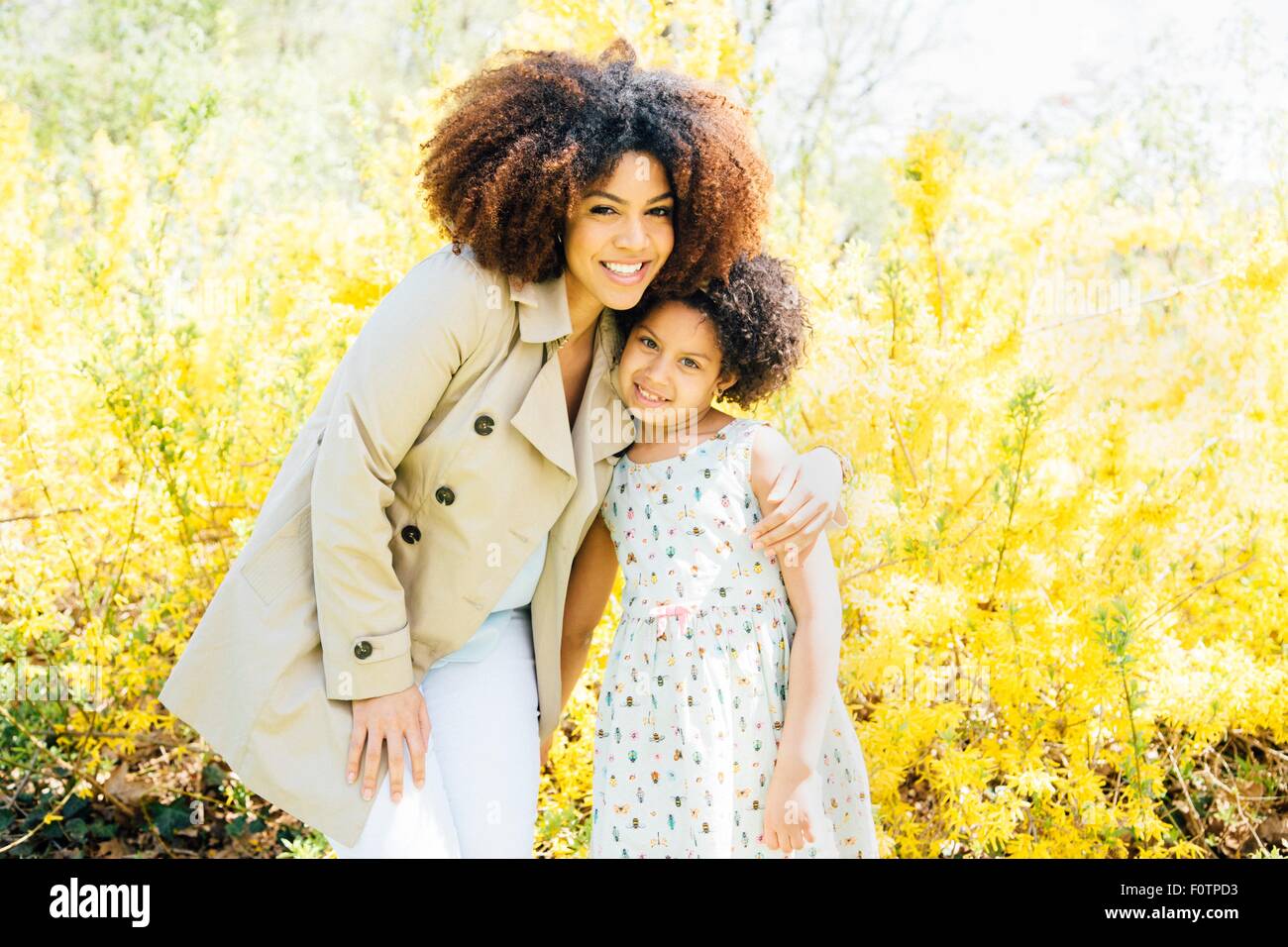 Portrait of mother with arm around daughter, looking at camera, smiling Stock Photo