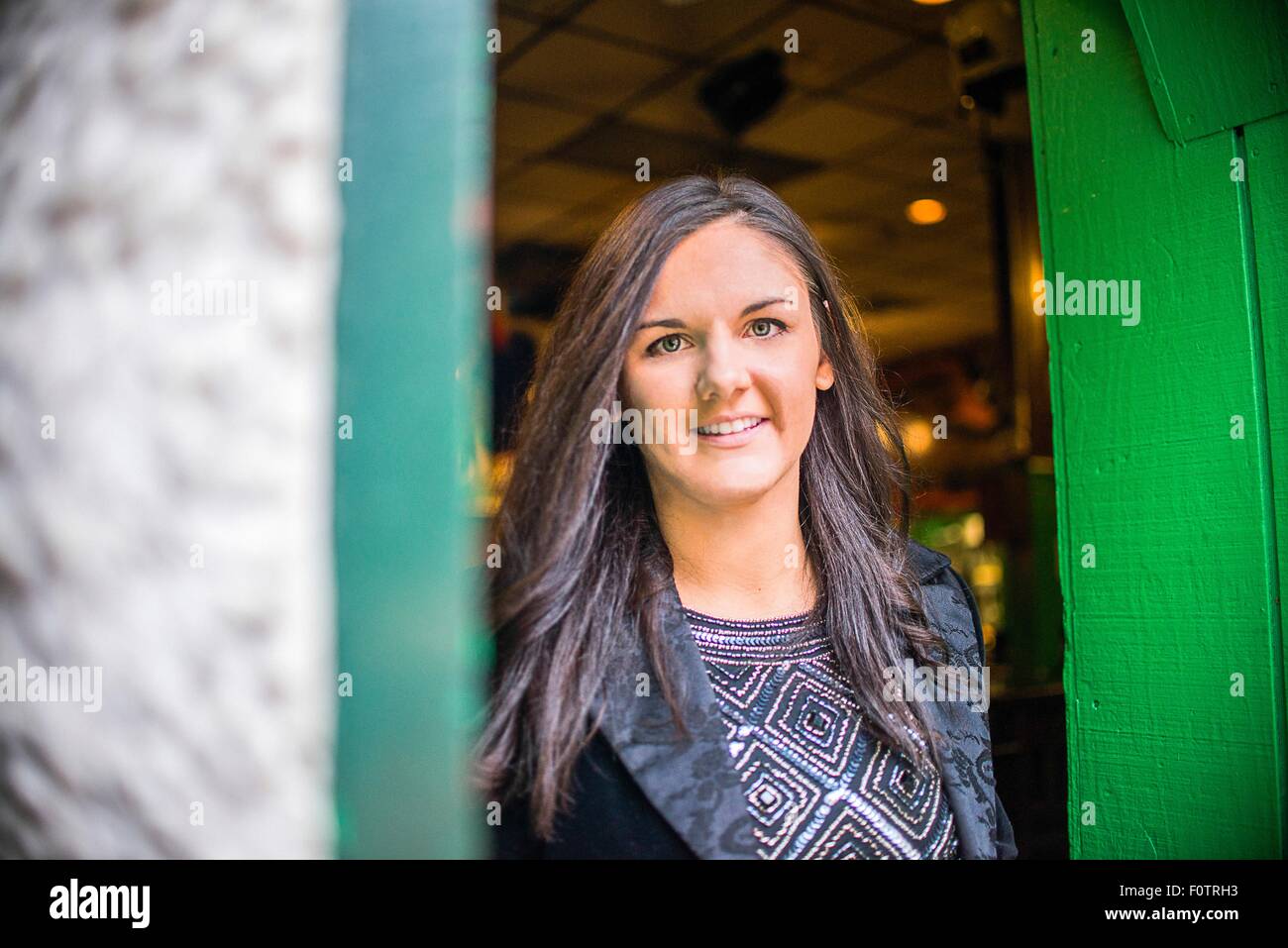 Portrait of young woman in green doorway Stock Photo
