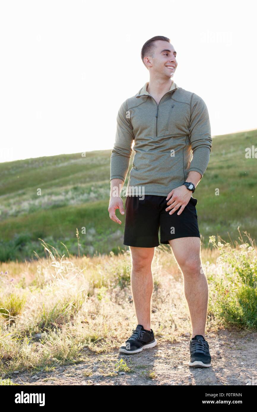 Portrait of young male runner on hillside Stock Photo