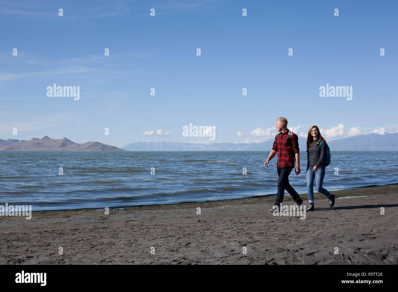 Young couple walking alongside waters edge, Great Salt Lake, Utah, USA Stock Photo