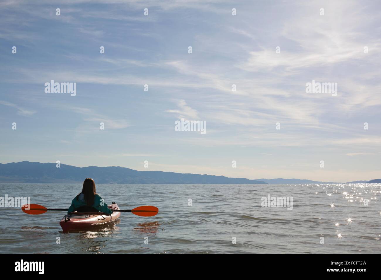 Rear view of young woman kayaker sitting in kayak on water, Great Salt Lake, Utah, USA Stock Photo