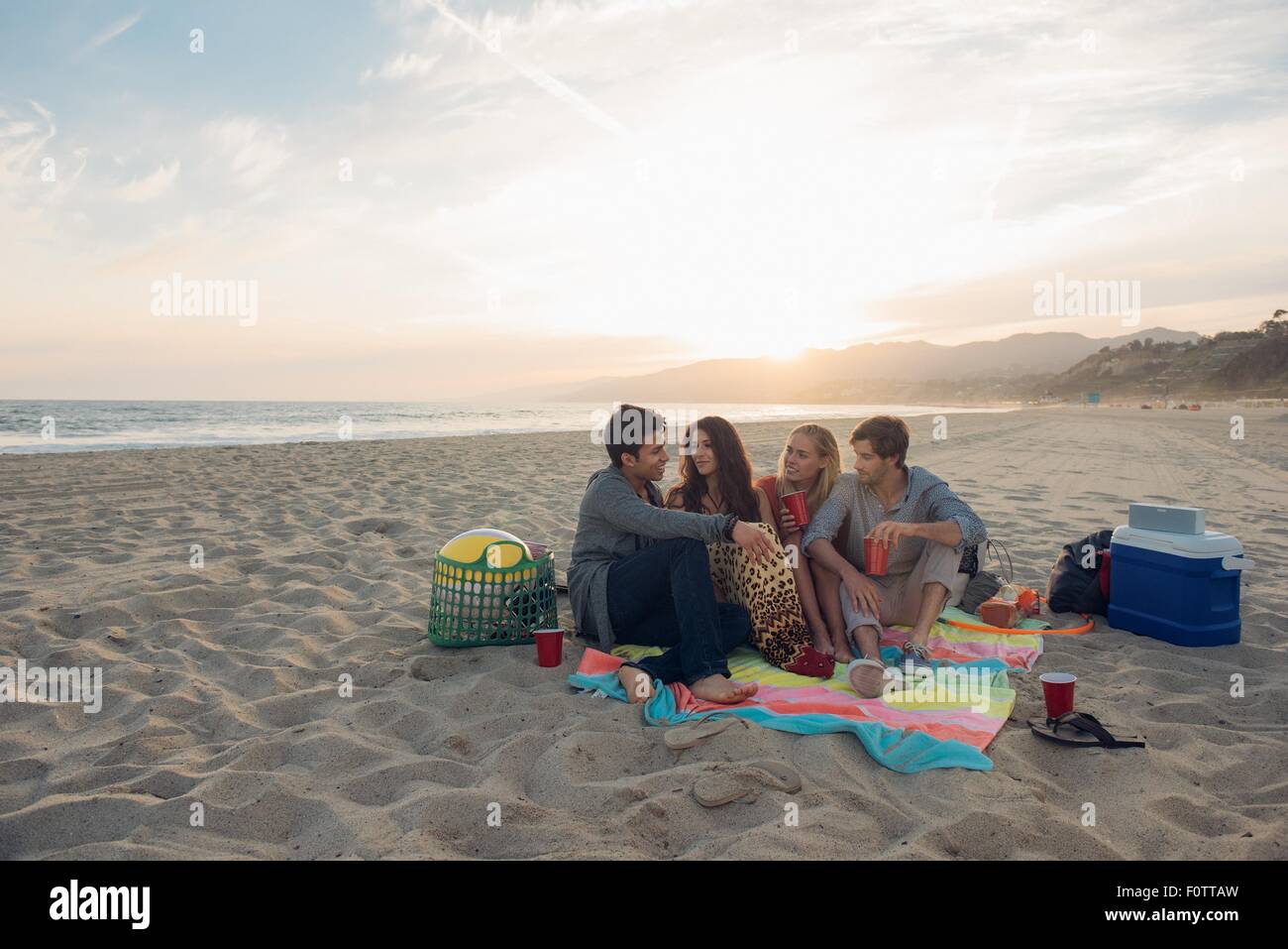 Group of friends having picnic on beach Stock Photo