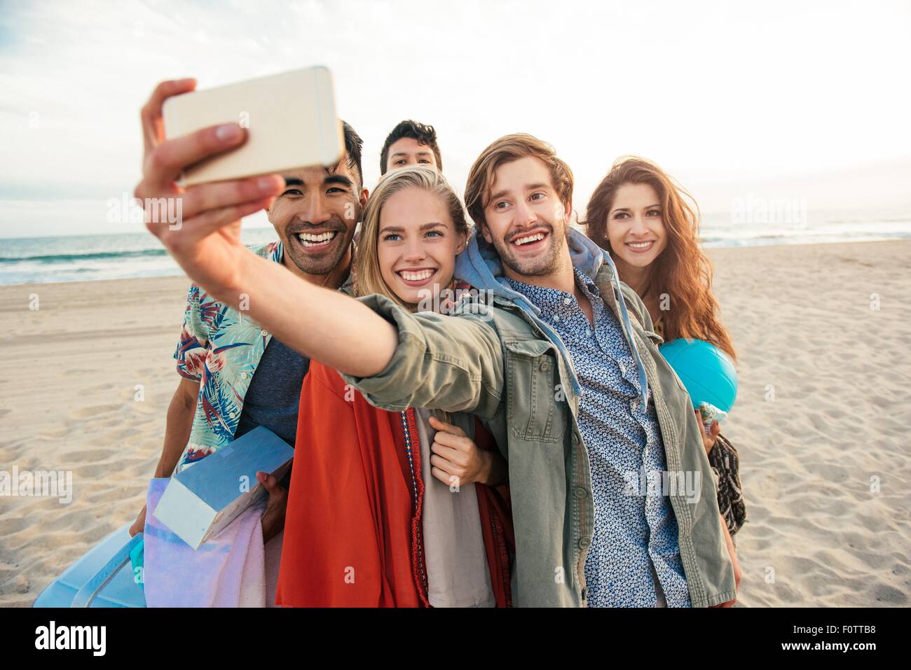 Group of friends on beach, taking self portrait with smartphone Stock Photo