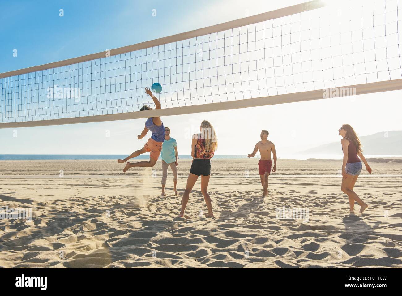 Group of friends playing volleyball on beach Stock Photo Alamy