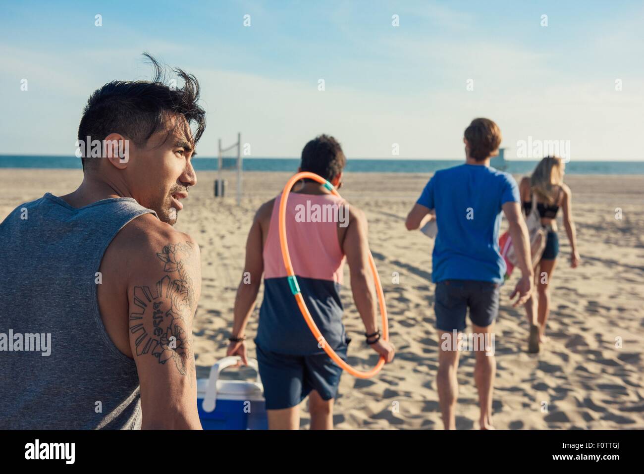 Group of friends walking on beach, rear view Stock Photo