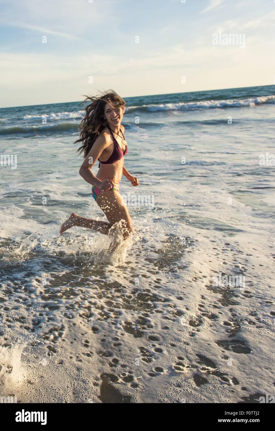 Young woman running in sea Stock Photo