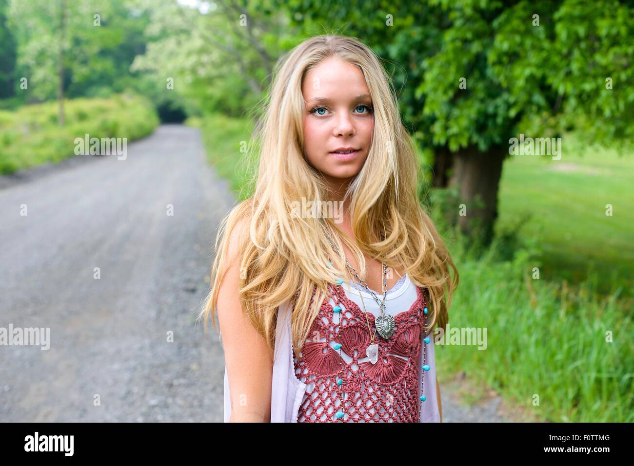 Portrait of fashionable young woman on rural road Stock Photo
