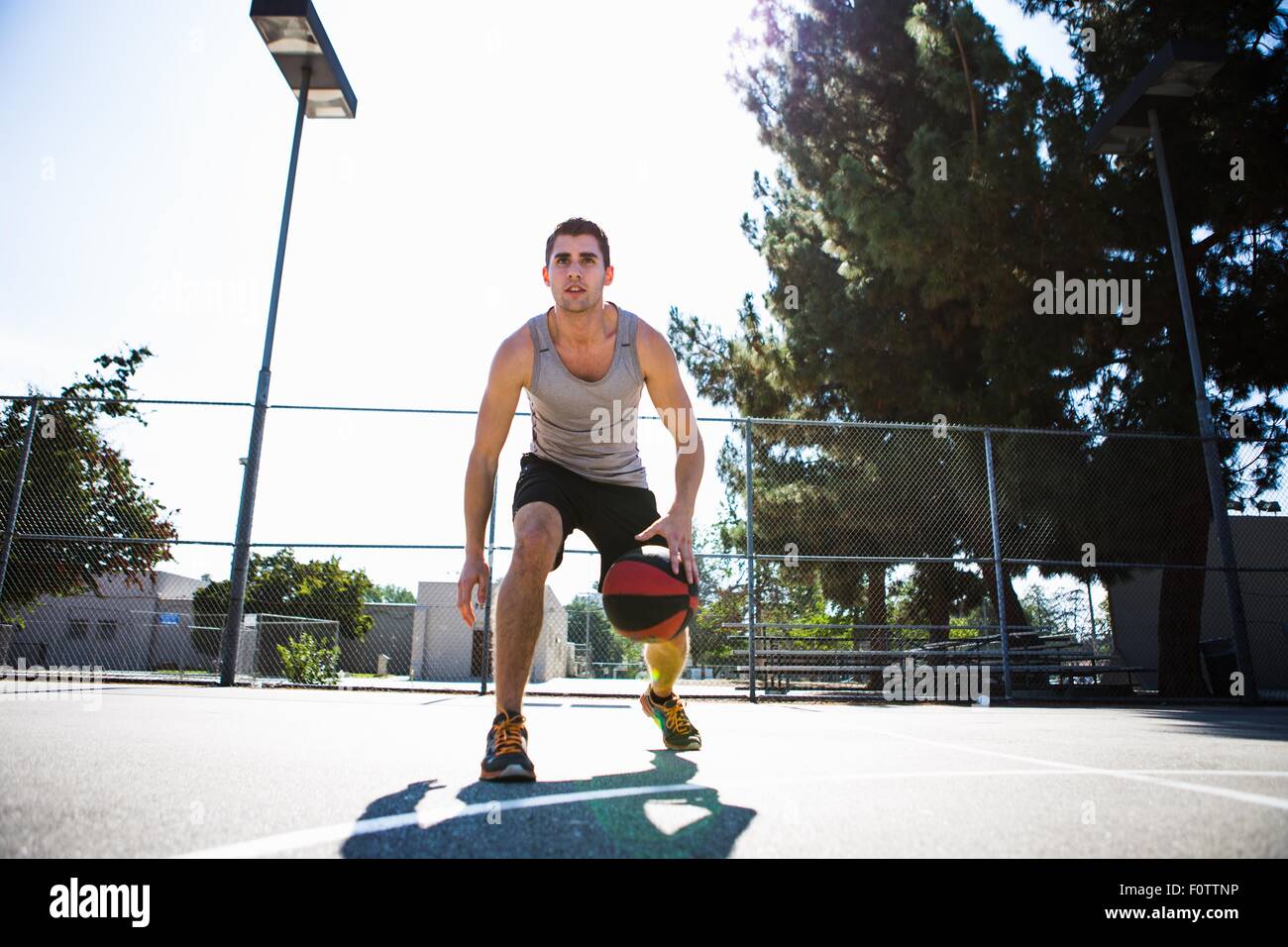 Young male basketball player preparing to throw ball on basketball court Stock Photo