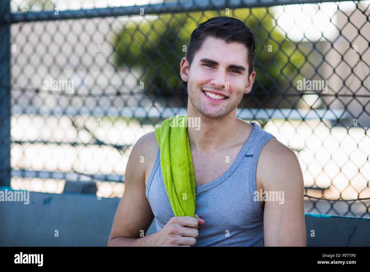 Portrait of smiling young male basketball player with towel on shoulder Stock Photo