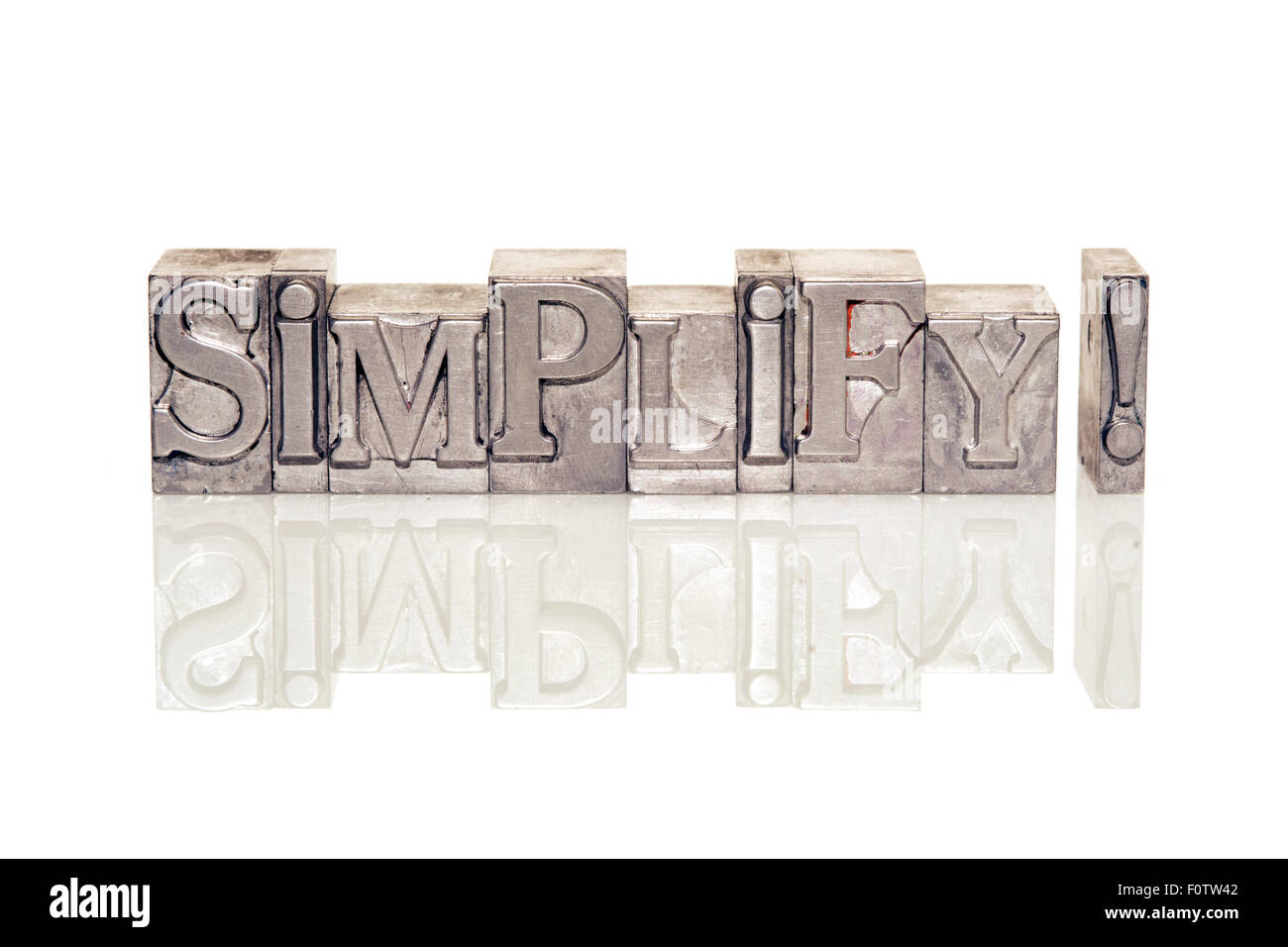 simplify exclamation made from metallic letterpress type on reflective surface Stock Photo