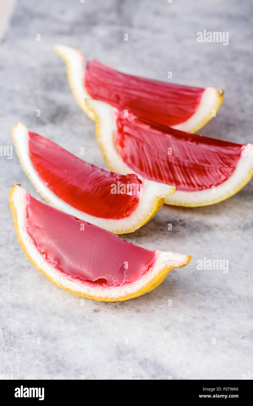 Lemon tequila strawberry jelly (jello) shots on a marble plate. Unusual