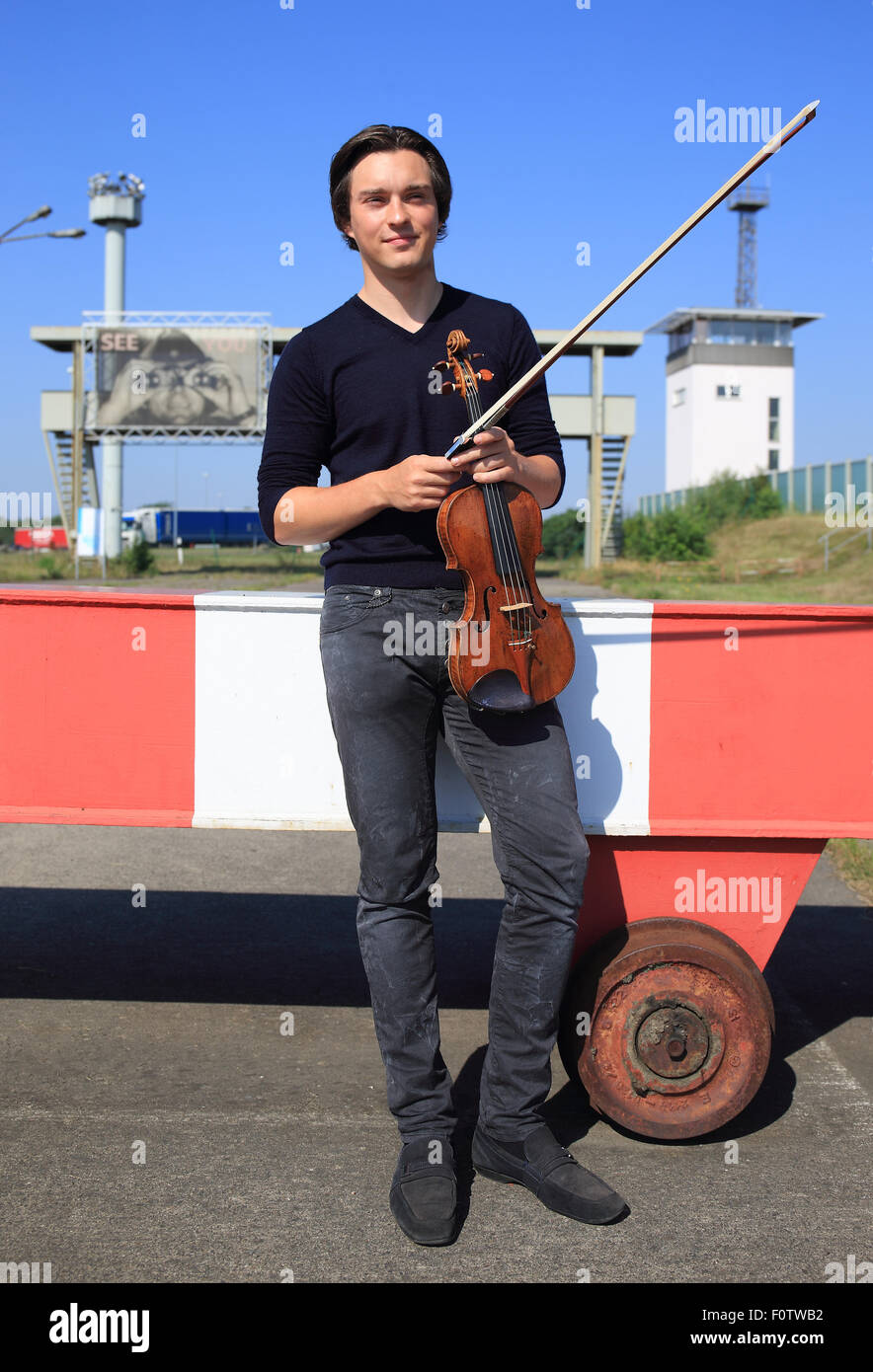 Marienborn, Germany. 21st Aug, 2015. Concert violinist Sven Stucke during a press shoot on the premises of the memorial 'Deutsche Teilung' (lt: German division) in Marienborn, Germany, 21 August 2015. There, the concert project 'The Sound of Unity - 25 Jahre Deutsche Einheit' (lt: 25 Years of German Unity) is being presented. Shows are being held on on the anniversaries of the Two Plus Four agreement in Mageburg. Photo: JENS WOLF/dpa/Alamy Live News Stock Photo