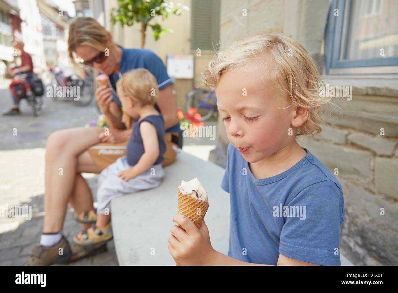 Mother and sons sitting outside eating icecream Stock Photo