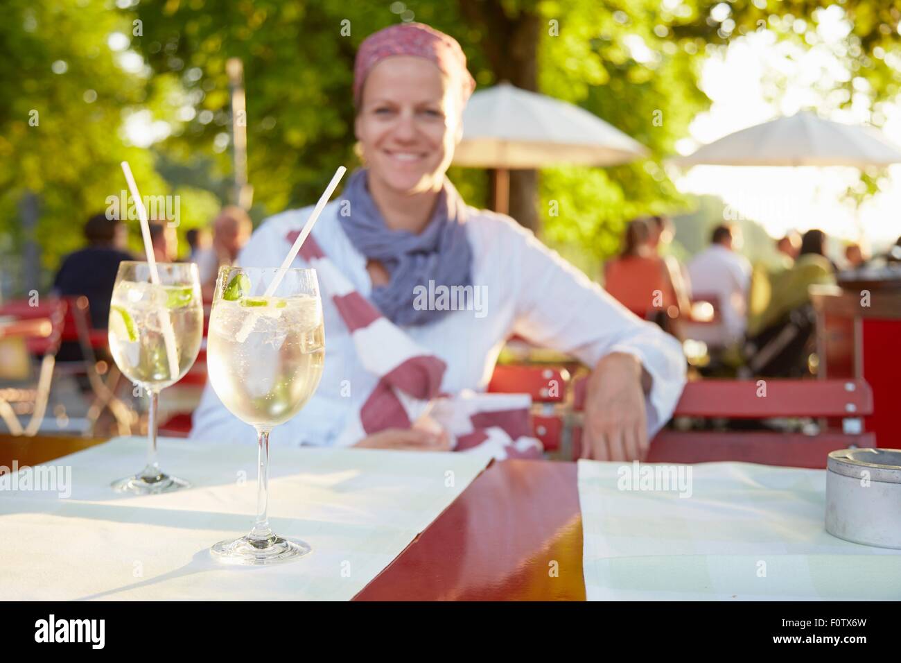 Mature woman, outdoors, sitting at table with drinks Stock Photo