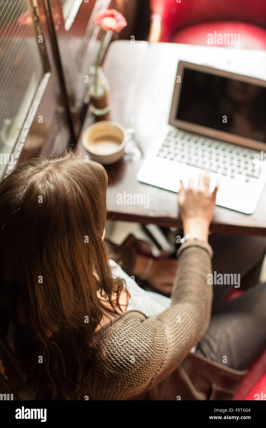 Mid adult woman using laptop, high angle view Stock Photo
