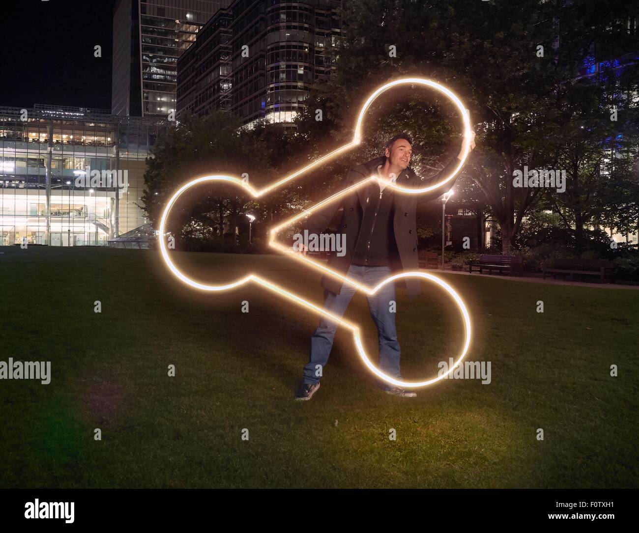 Artist painting share symbol outside office building at night Stock Photo