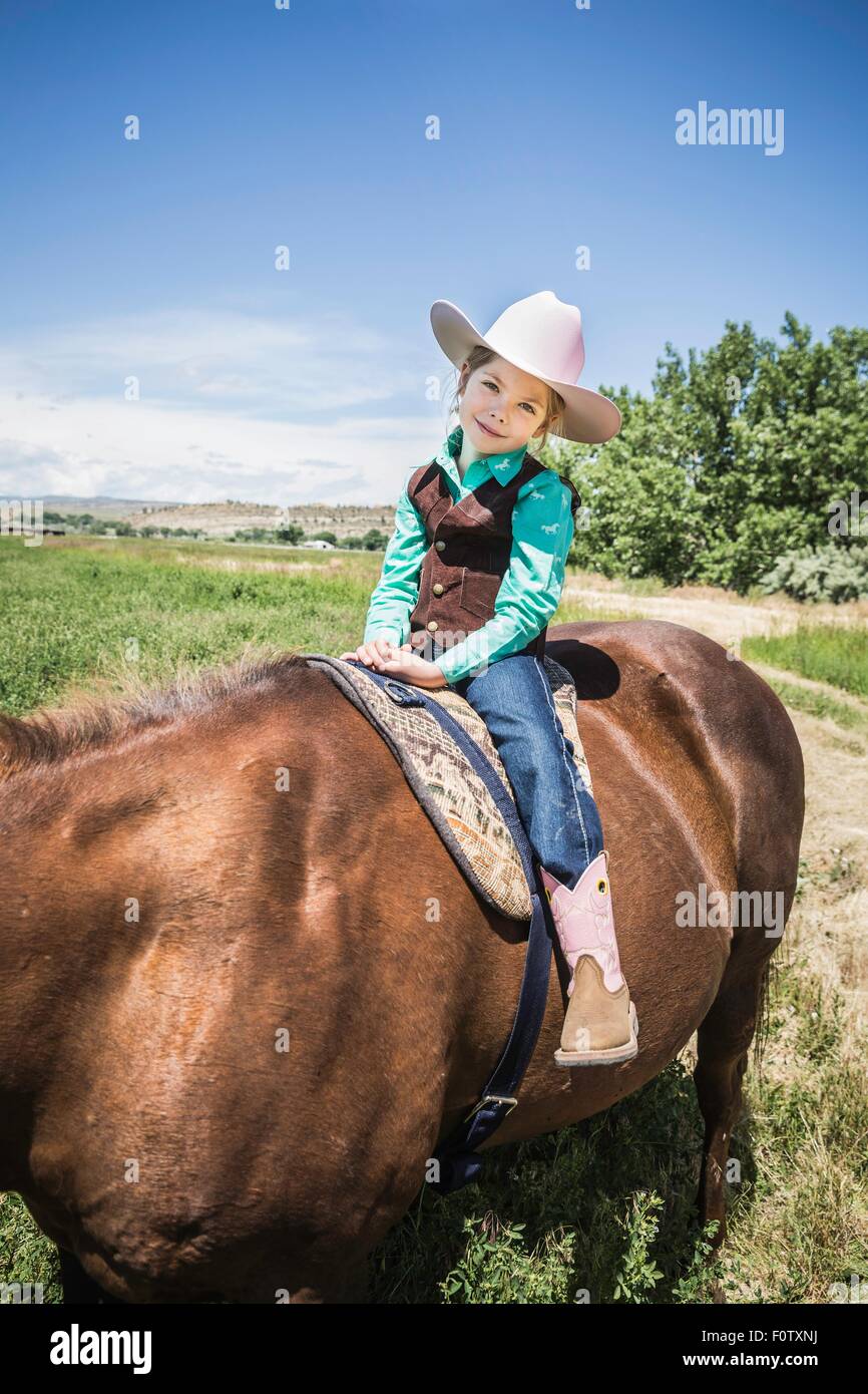 Girl wearing cowboy boots and hat on horse Stock Photo - Alamy