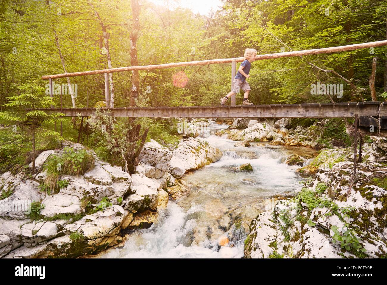 Boy running on wooden footbridge, Bovec, Soca, Slovenia Stock Photo
