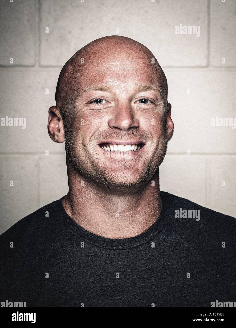 Portrait of smiling bald young man posing before workout Stock Photo