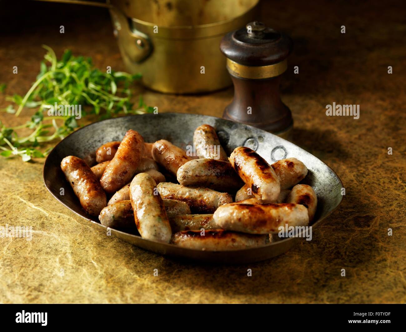 Rustic still life with cocktail sausages in metal serving dish Stock Photo