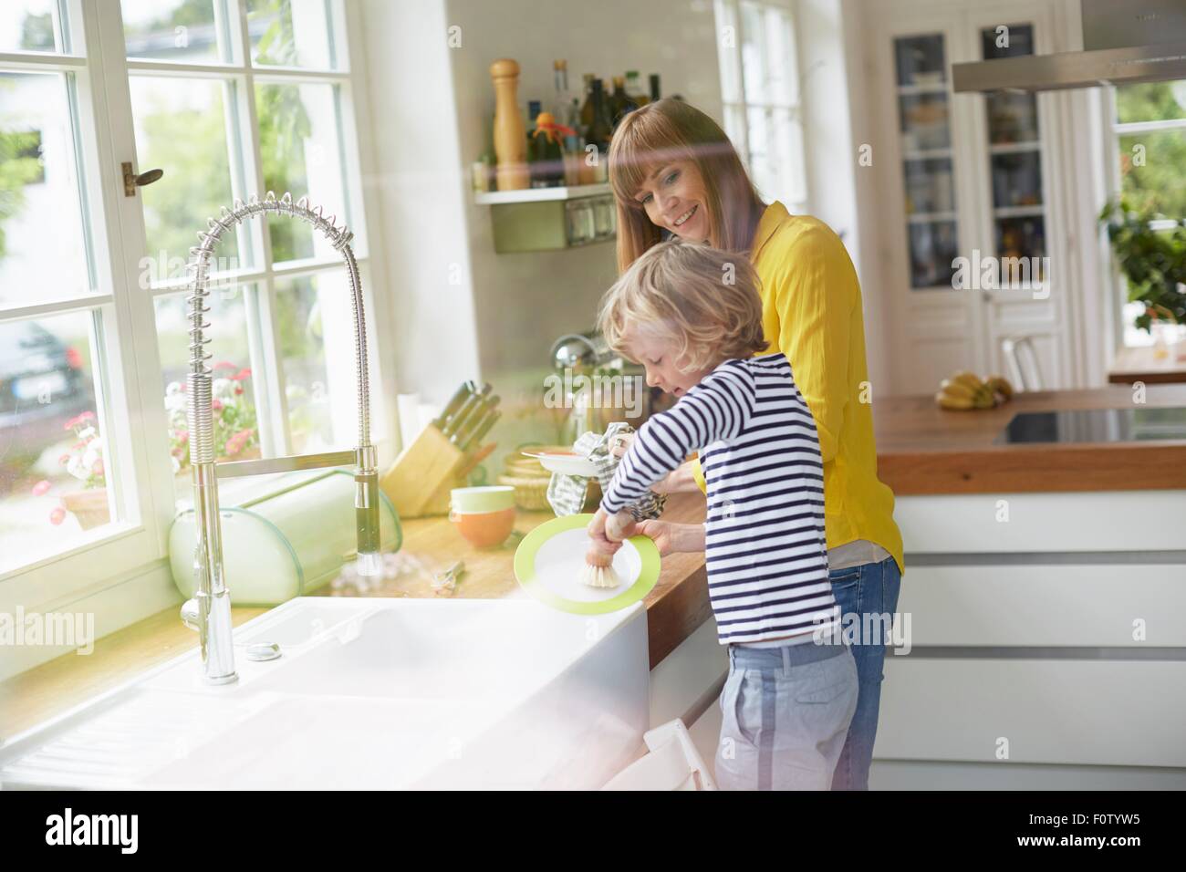 Mother and son doing washing up Stock Photo