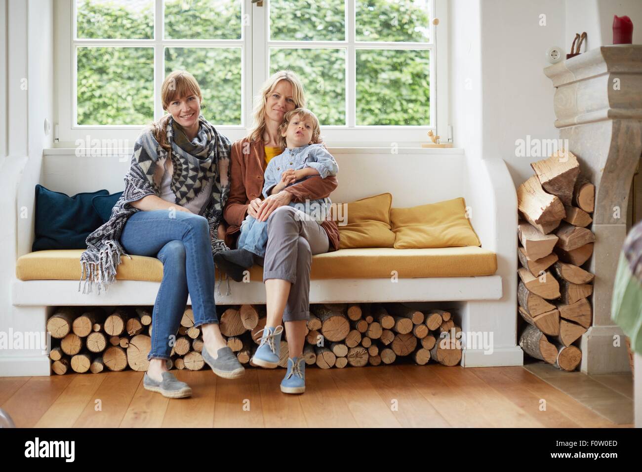 Adult women sitting in window seat with boy sitting on lap Stock Photo