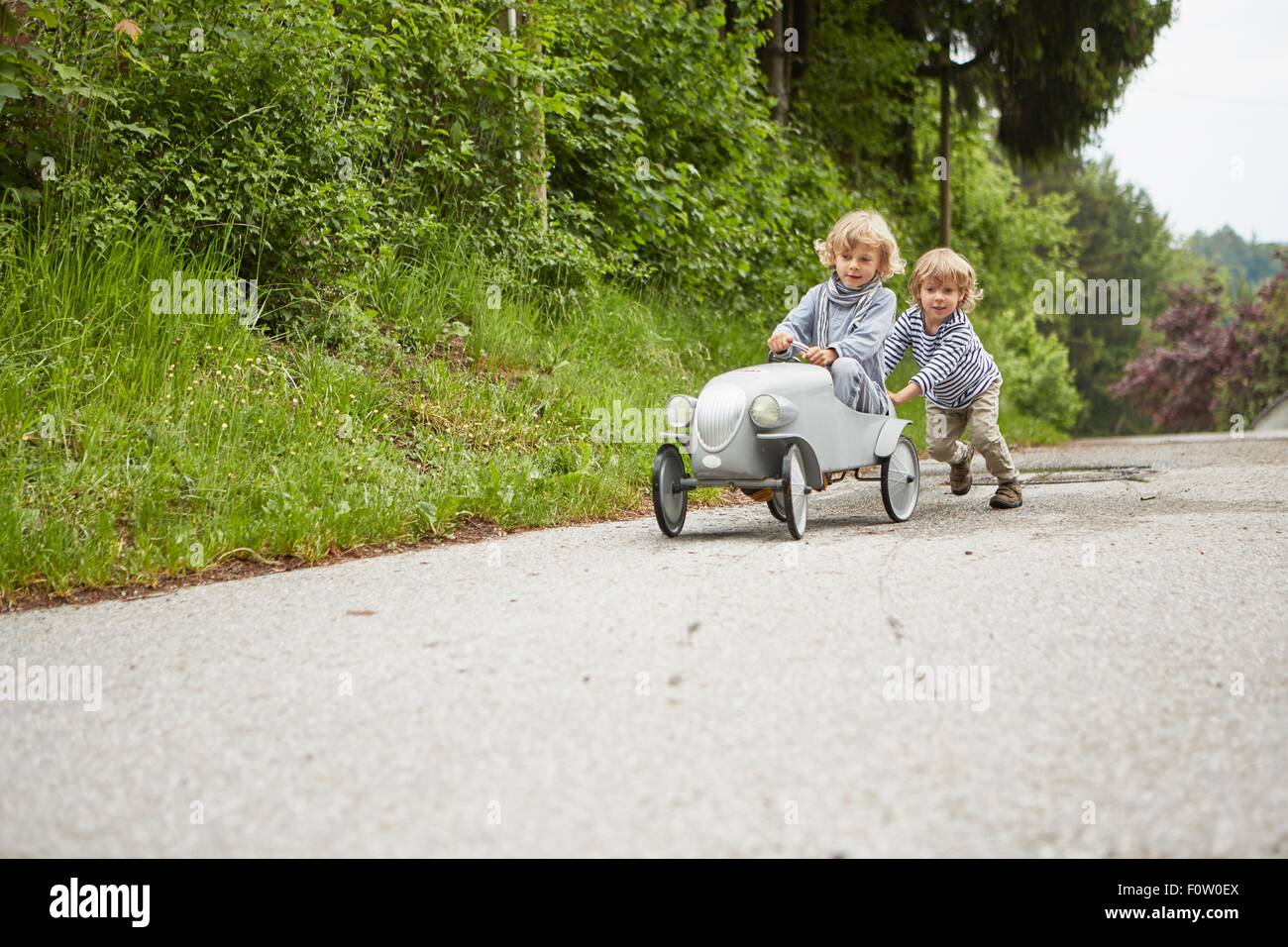Two boys playing with vintage toy car Stock Photo