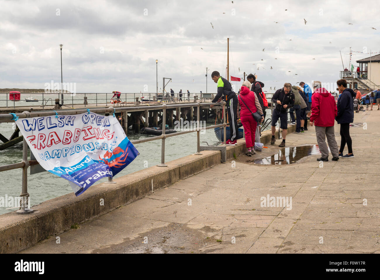 Families gather at the quayside to watch or participate in the Welsh open crabbing championship in Aberdyfi Wales. Stock Photo