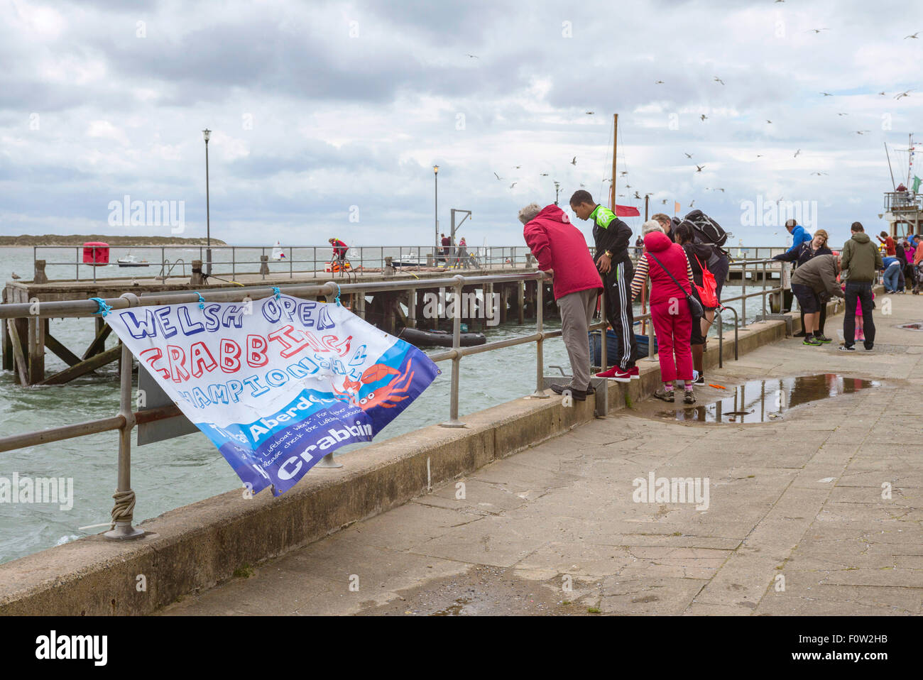 Families gather at the quayside to watch or participate in the Welsh open crabbing championship in Aberdyfi Wales. Stock Photo