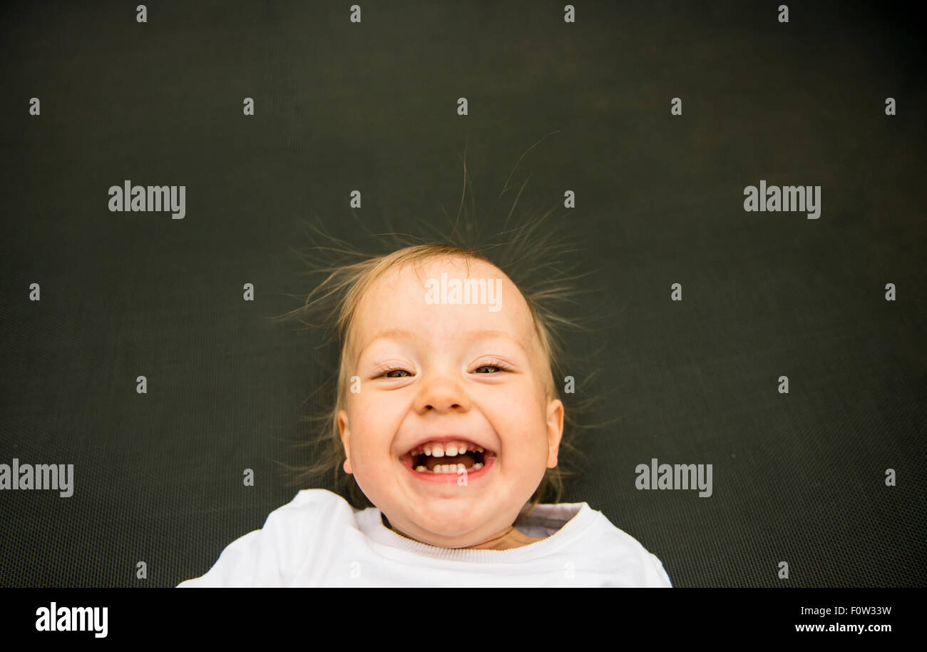 Portrait of laughing baby with standing hair from static electricity Stock Photo